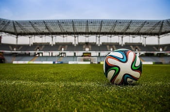 Ein Fußball auf dem Spielfeld eines Stadions.