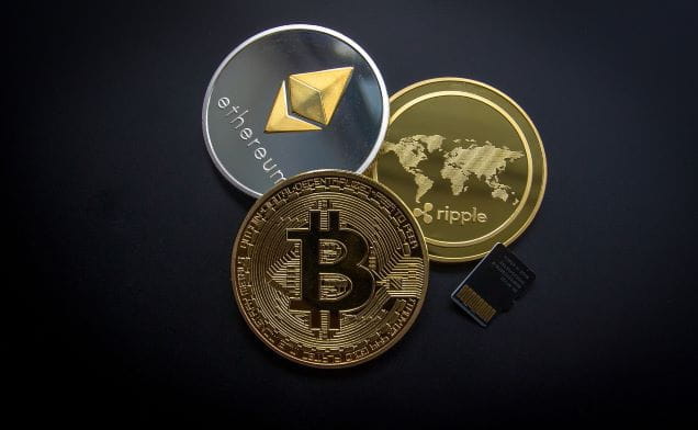 Münzen der Kryptowährungen Bitcoin, Ripple und Ethereum.