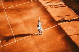 Ein Tennisspieler beim Aufschlag auf einem Tennisplatz 