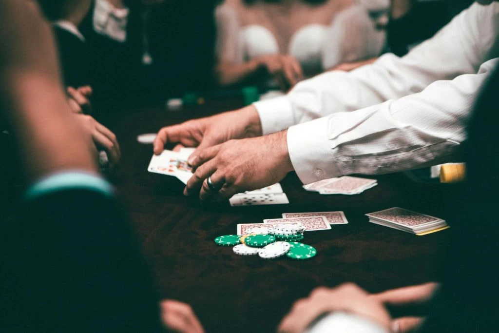Hände von Pokerspielern mit Karten und Chips