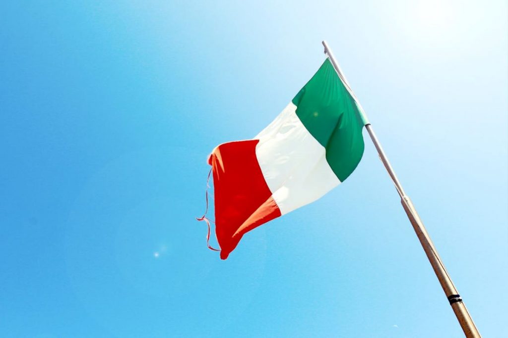 Italienische Flagge vor blauem Himmel.