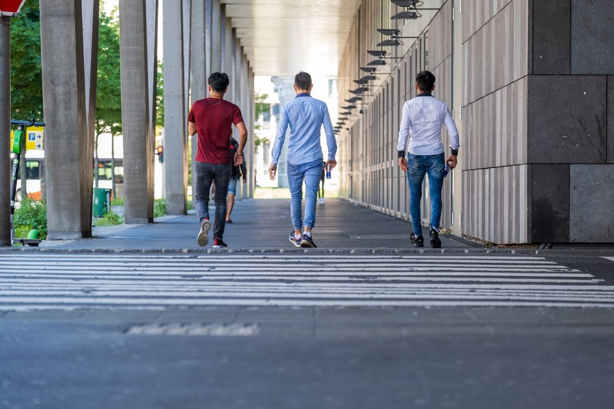 Aufnahme von drei jungen Männern auf dem Bürgersteig.