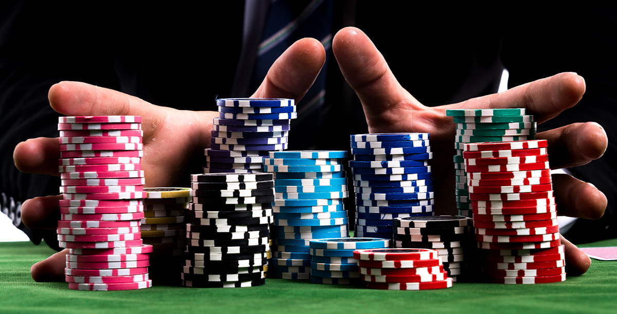 Eine Poker-Spieler schiebt die Spielchips in die Mitte des Tisches.