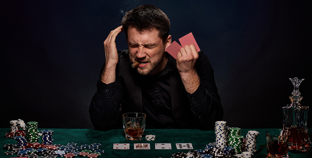 Eine Poker-Spieler sitzt am Pokertisch und ist wütend.