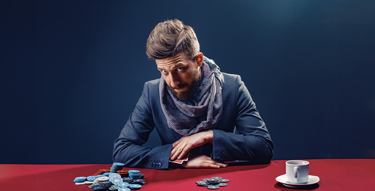 Eine Pokerspieler mit Sonnenbrille sitzt an einem Pokertisch.