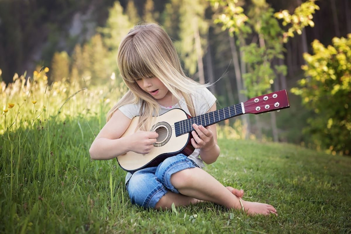 Aufnahme eines Mädchens mit einer Gitarre in der Hand.