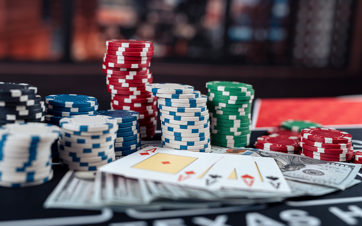 Pokerchips, Geldscheine und Spielkarten auf einem Pokertisch.