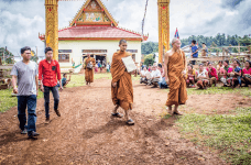 Menschen vor einem buddhistischen Tempel im Laos.