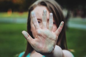 Aufnahme einer Frau, die ihre Hand in einer Abwehrhaltung in die Kamera hält.